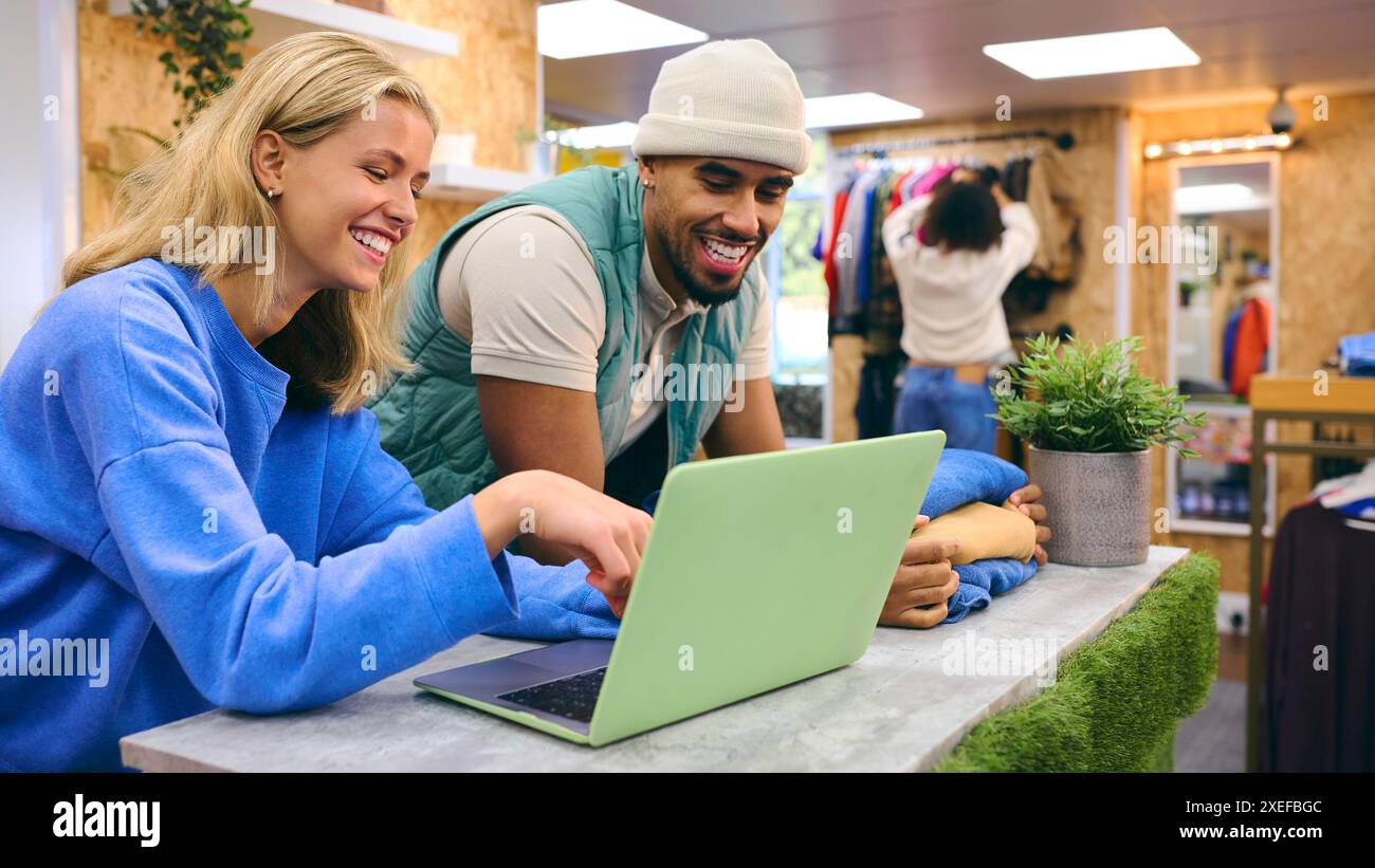 Verkäuferin Und Verkäuferin, Die An Der Kasse Mit Laptop Im Pop-Up-Mode- Oder Kleiderladen Arbeitet Stockfoto