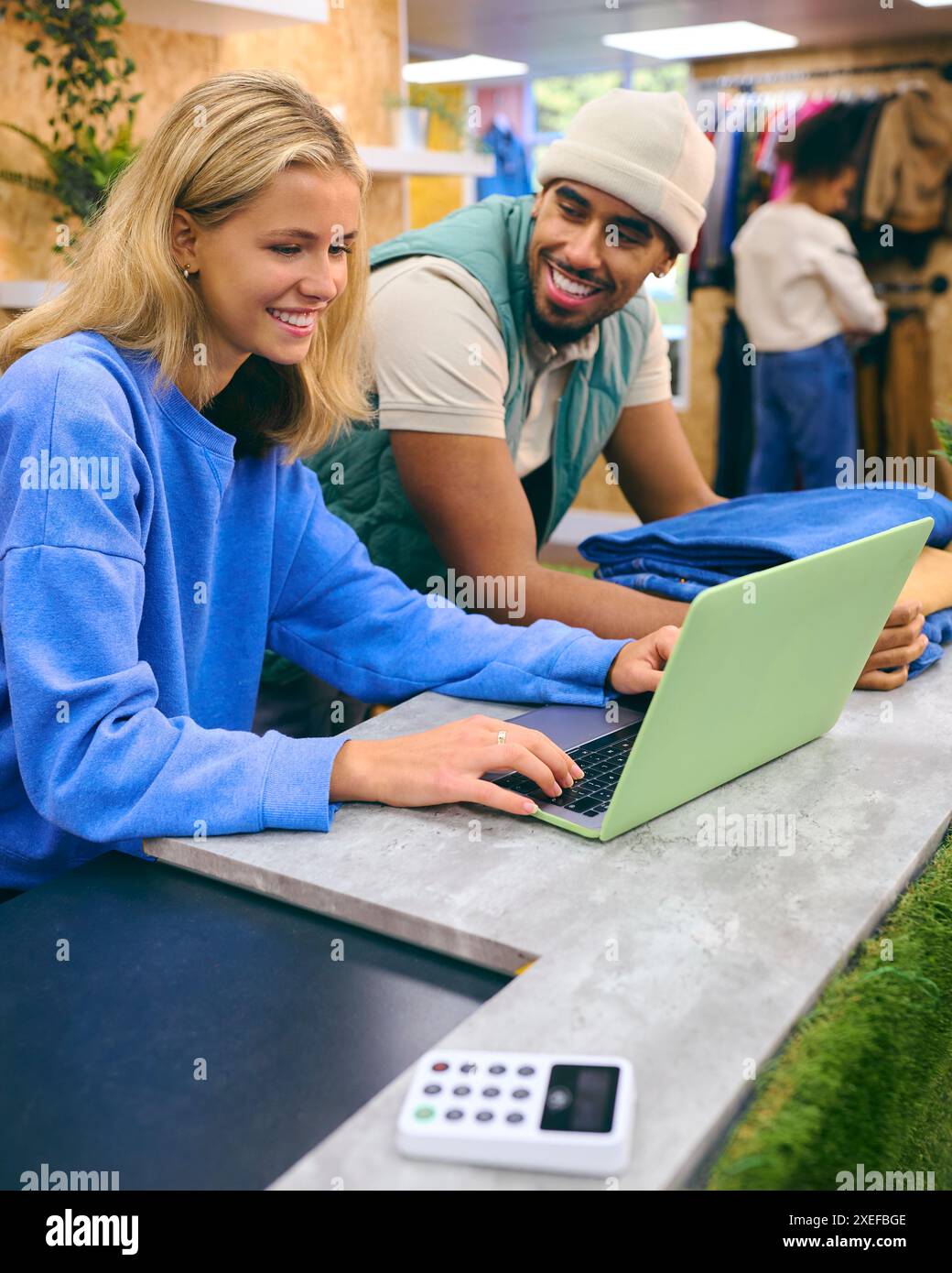 Verkäuferin Und Verkäuferin, Die An Der Kasse Mit Laptop Im Pop-Up-Mode- Oder Kleiderladen Arbeitet Stockfoto