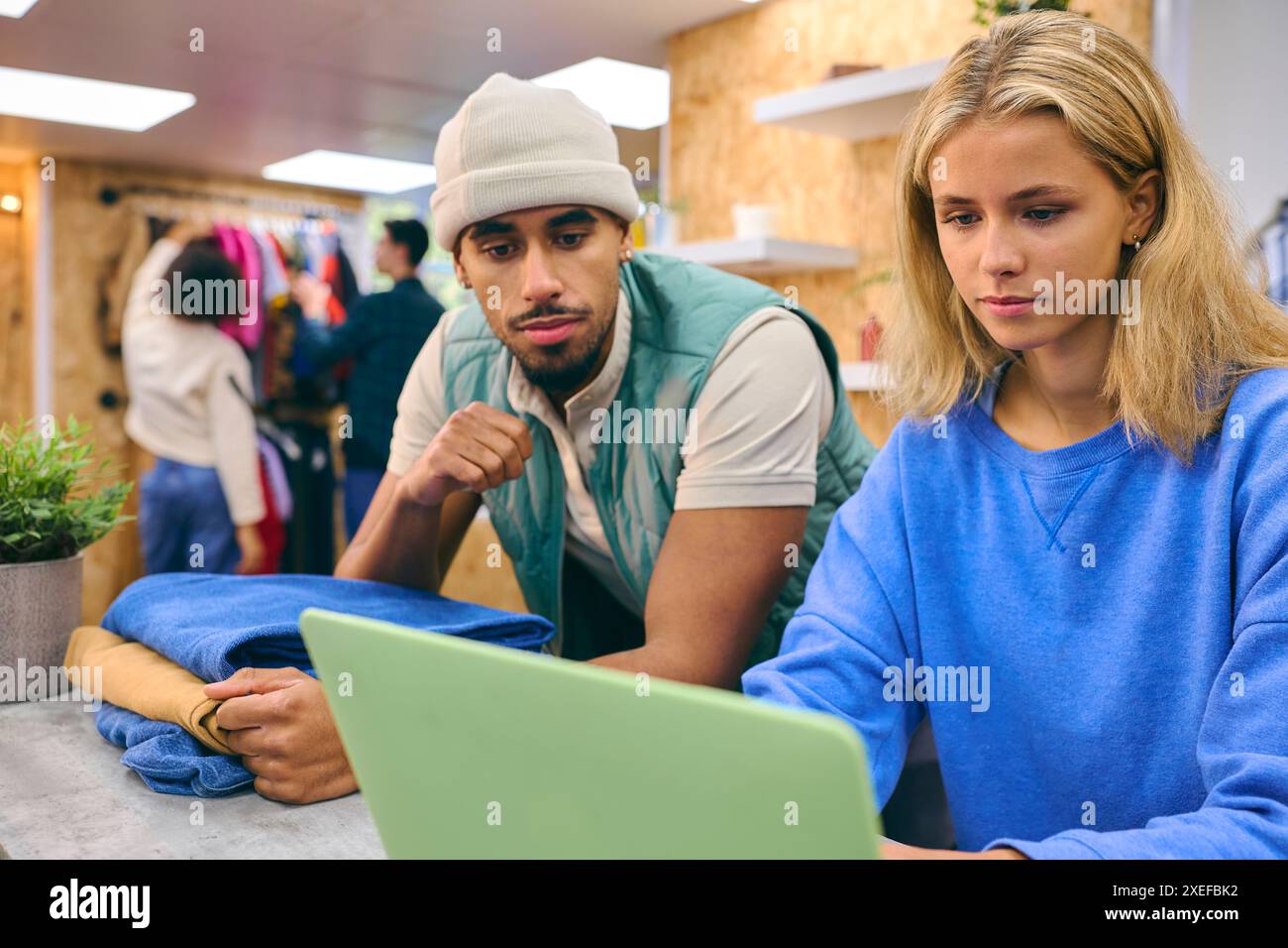 Verkäuferin Und Verkäuferin, Die An Der Kasse Mit Laptop Im Pop-Up-Mode- Oder Kleiderladen Arbeitet Stockfoto