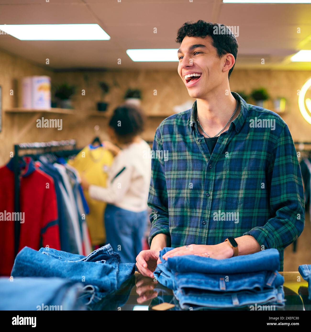 Männlicher Vertriebsmitarbeiter Oder Kunde Sortieren Und Sehen Sich Jeans Im Fashion Store An Stockfoto