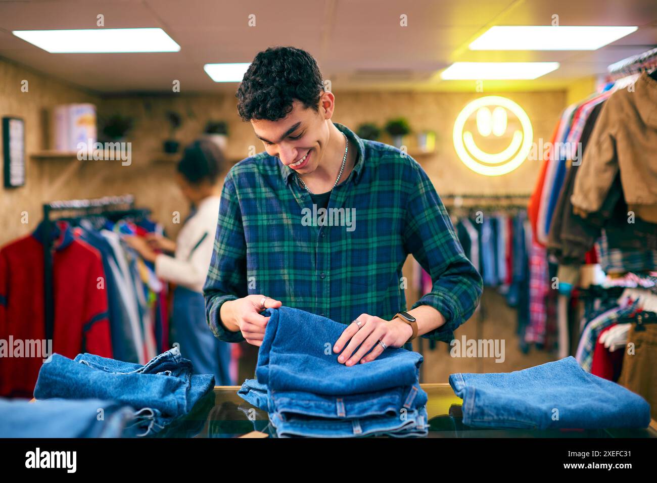 Männlicher Vertriebsmitarbeiter Oder Kunde Sortieren Und Sehen Sich Jeans Im Mode- Oder Bekleidungsgeschäft An Stockfoto