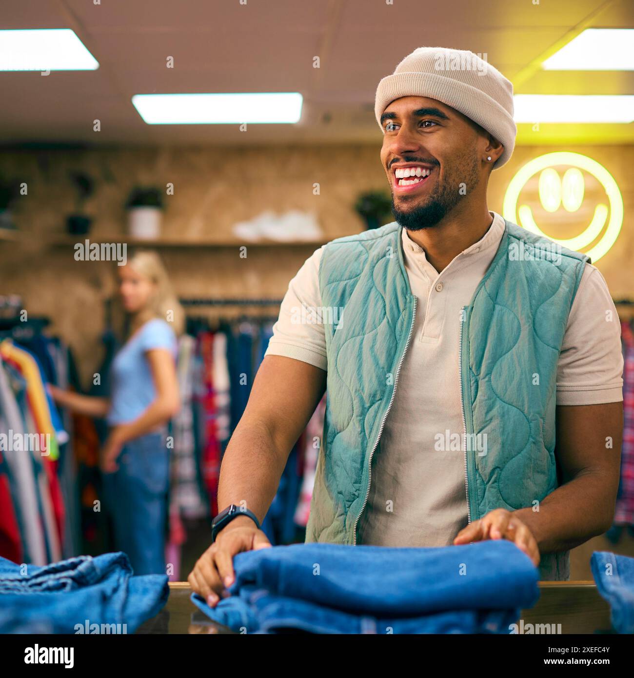 Männlicher Vertriebsmitarbeiter Oder Kunde Sortieren Und Sehen Sich Jeans Im Fashion Store An Stockfoto