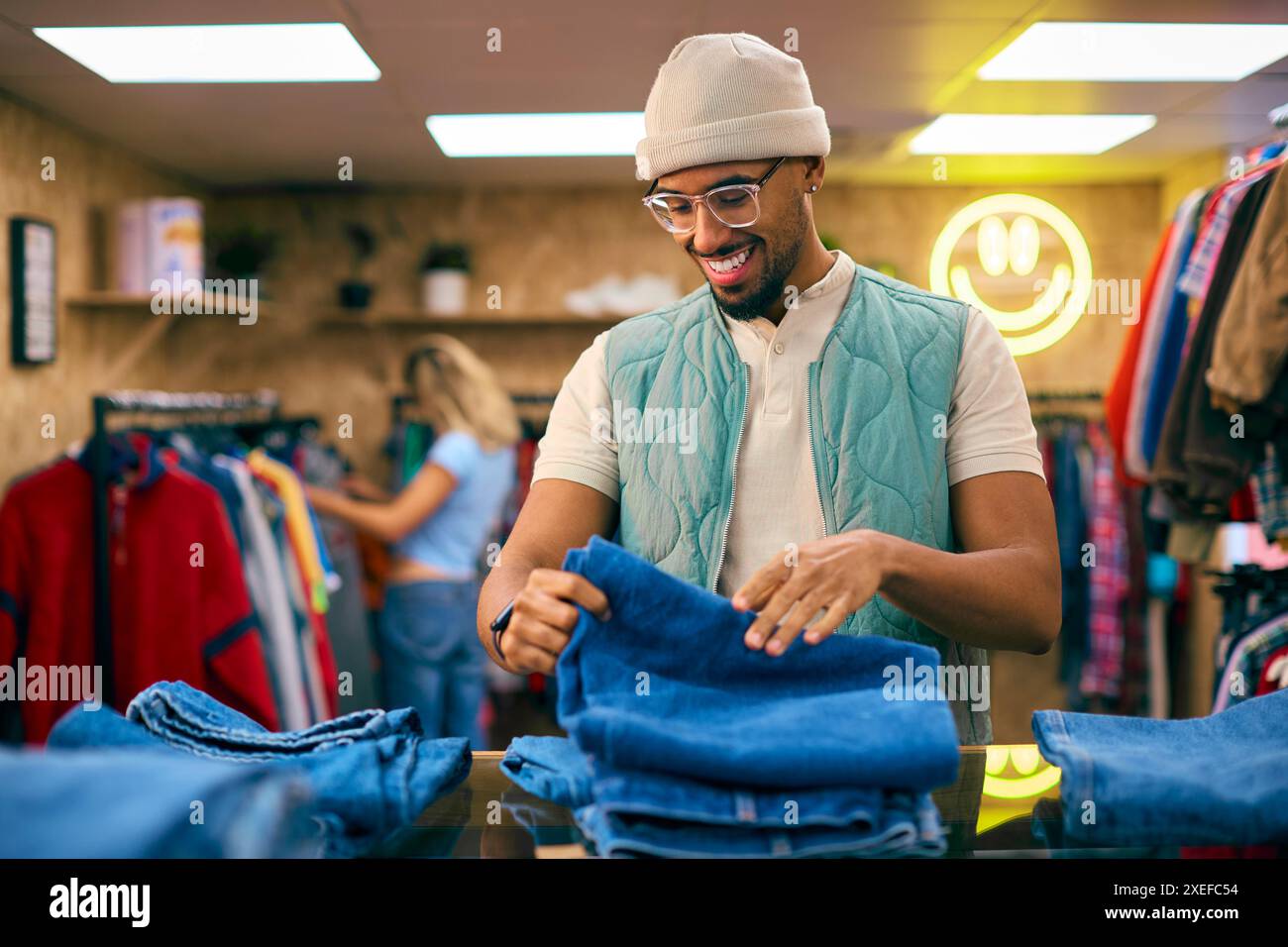Männlicher Vertriebsmitarbeiter Oder Kunde Sortieren Und Sehen Sich Jeans Im Fashion Store An Stockfoto