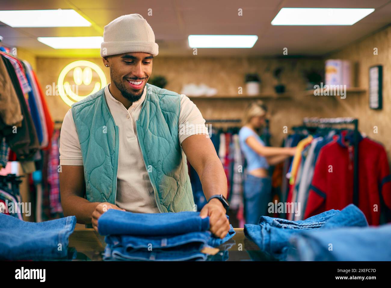 Männlicher Vertriebsmitarbeiter Oder Kunde Sortieren Und Sehen Sich Jeans Im Fashion Store An Stockfoto