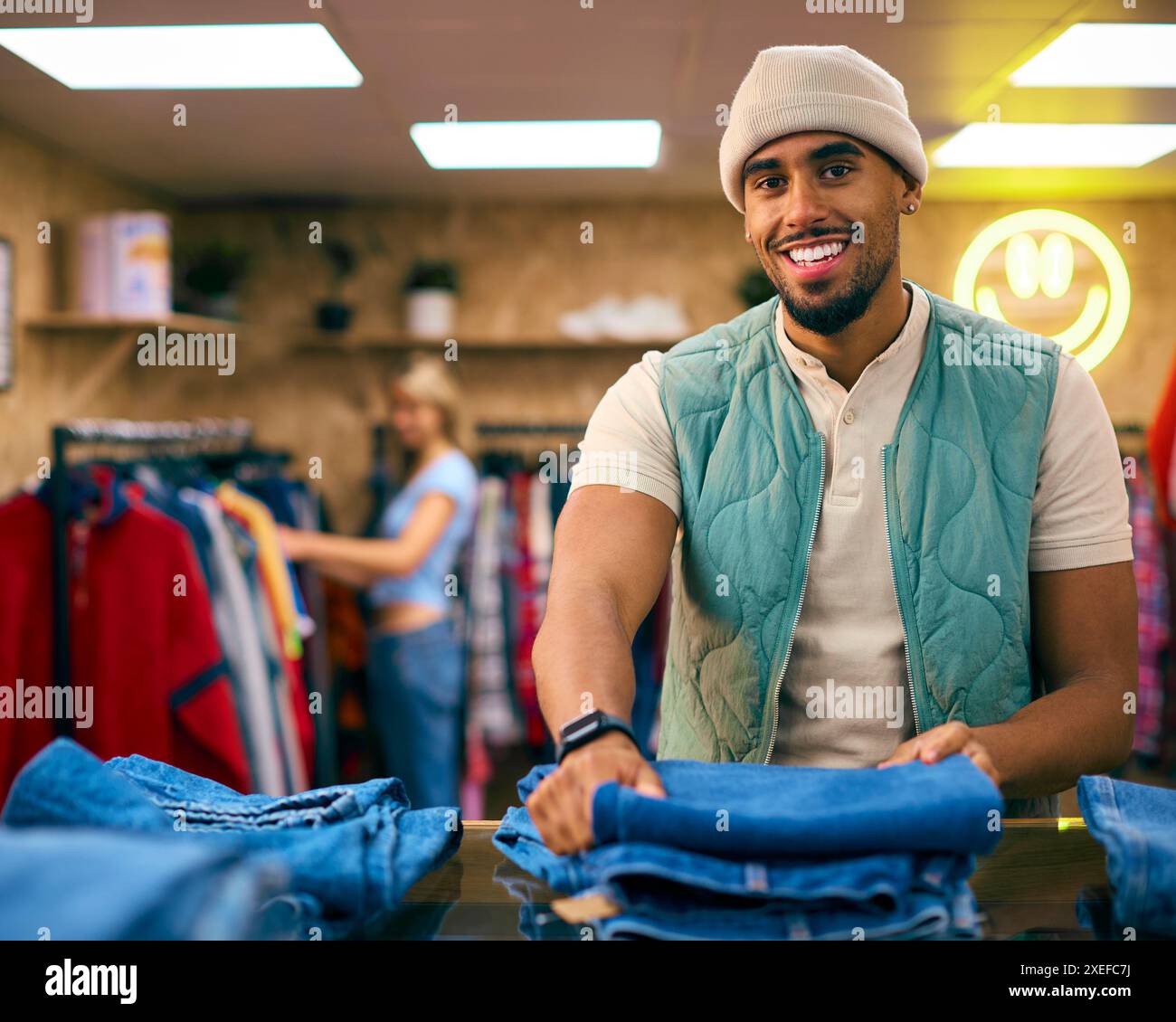 Porträt Eines Männlichen Vertriebsassistenten Oder Kunden, Der Im Fashion Store Jeans Sortiert Und Ansieht Stockfoto