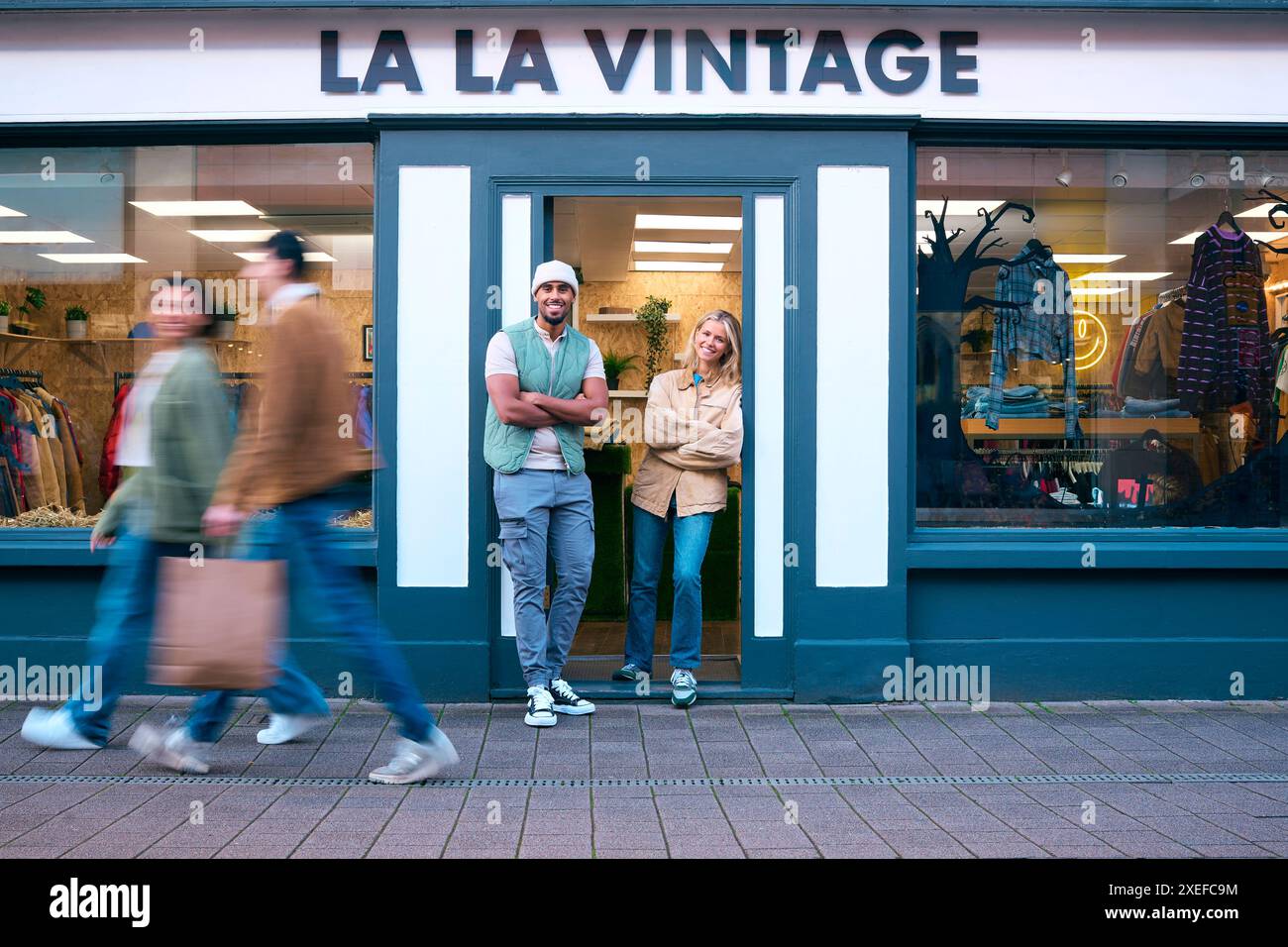 Porträt Von Vertriebsassistenten Oder Eigentümern, Die Außerhalb Von Mode- Oder Kleiderläden Stehen Stockfoto
