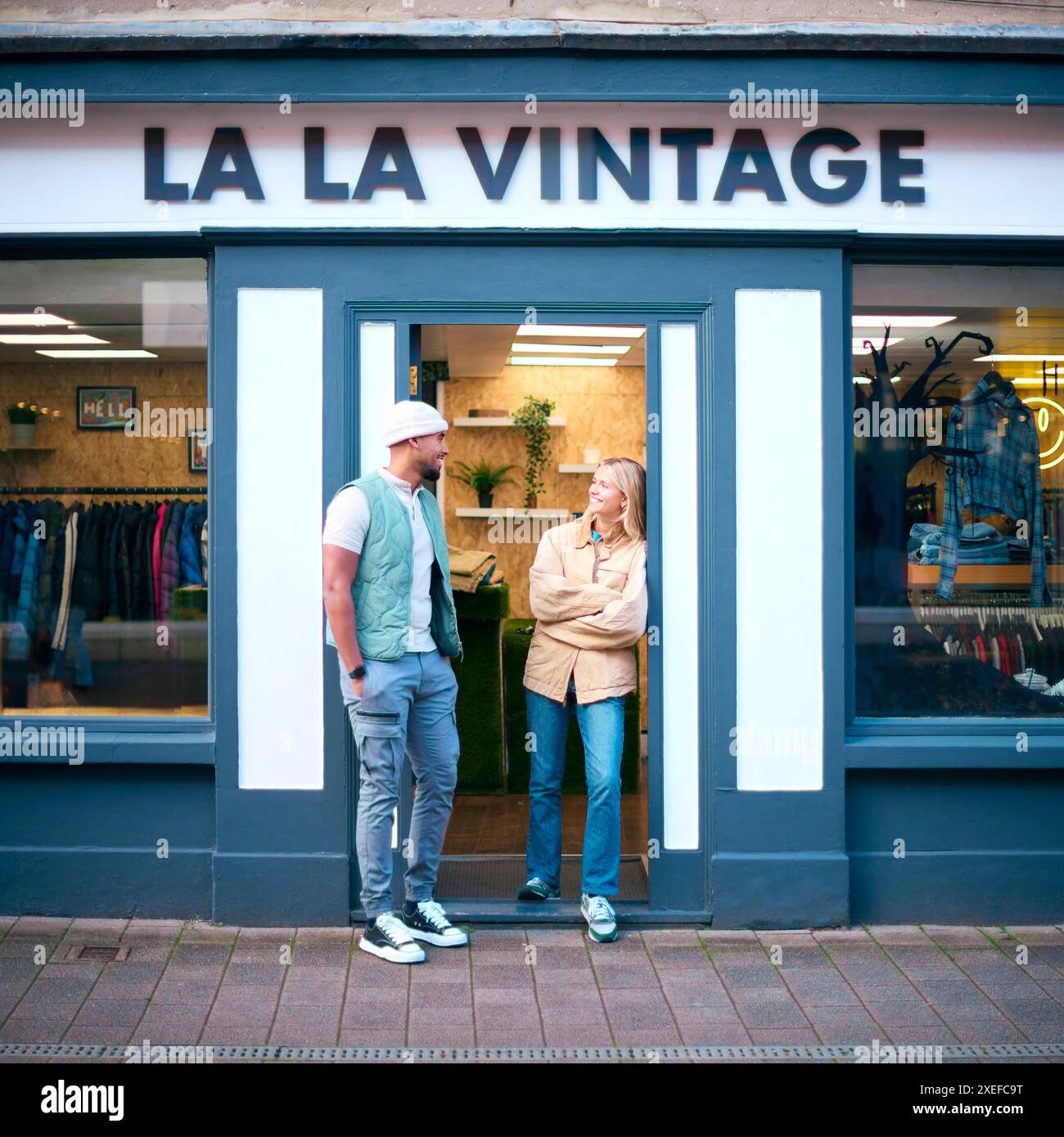 Porträt Von Vertriebsassistenten Oder Eigentümern, Die Außerhalb Von Mode- Oder Kleiderläden Stehen Stockfoto