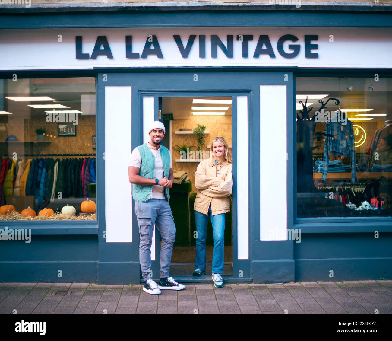 Porträt Von Vertriebsassistenten Oder Eigentümern, Die Außerhalb Von Mode- Oder Kleiderläden Stehen Stockfoto