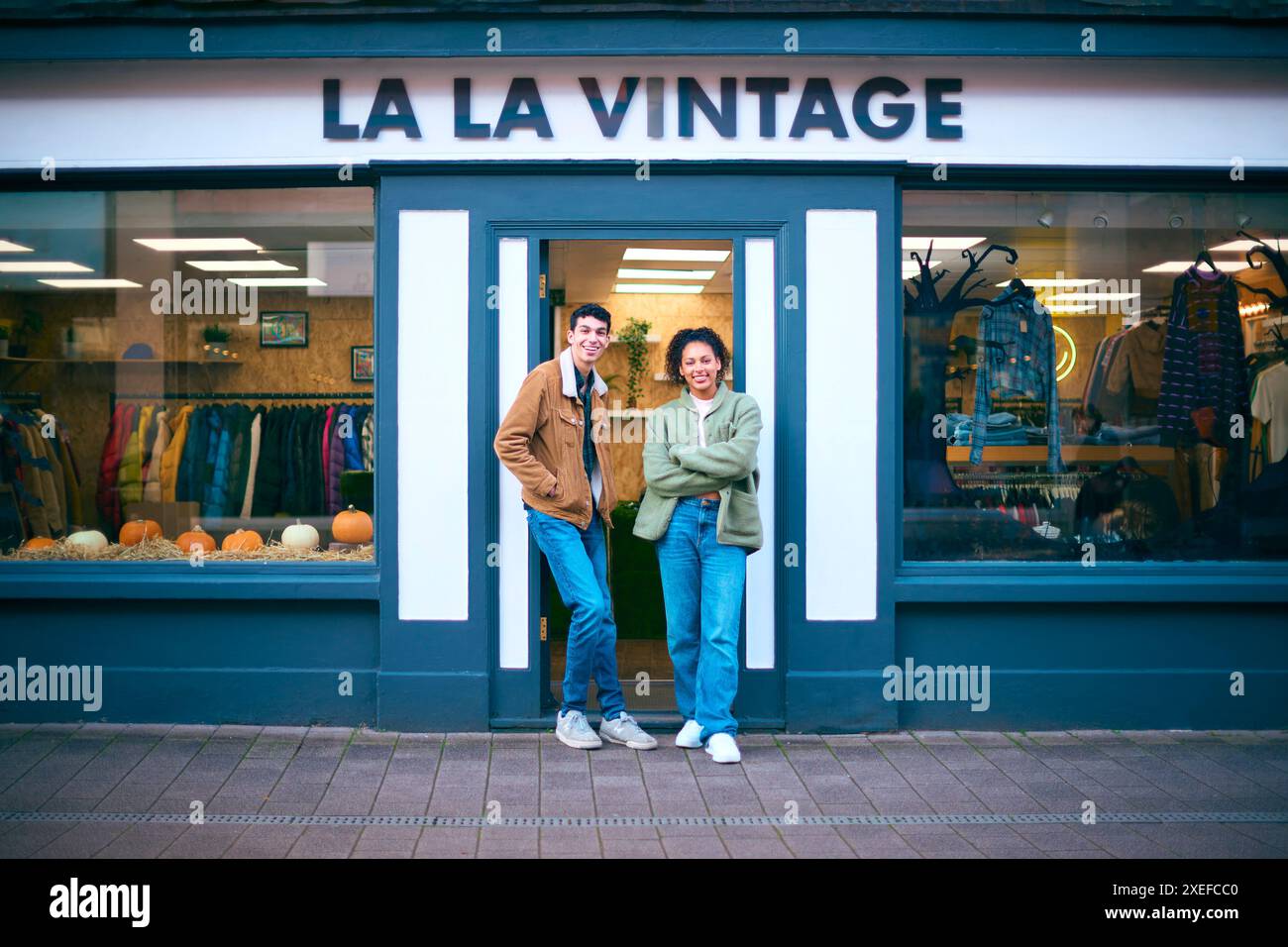 Porträt Von Vertriebsassistenten Oder Eigentümern, Die Außerhalb Von Mode- Oder Kleiderläden Stehen Stockfoto