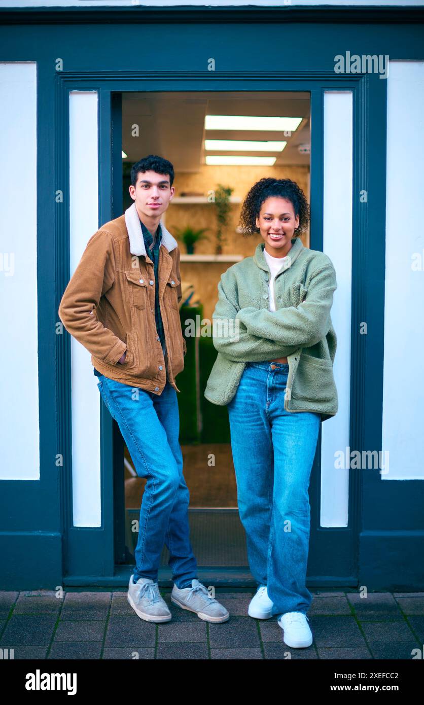 Porträt Von Vertriebsassistenten Oder Eigentümern, Die Außerhalb Von Mode- Oder Kleiderläden Stehen Stockfoto