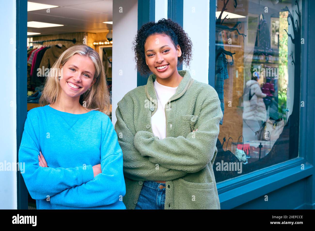 Porträt Von Weiblichen Vertriebsassistenten Oder Eigentümern, Die Außerhalb Von Mode- Oder Kleiderläden Stehen Stockfoto