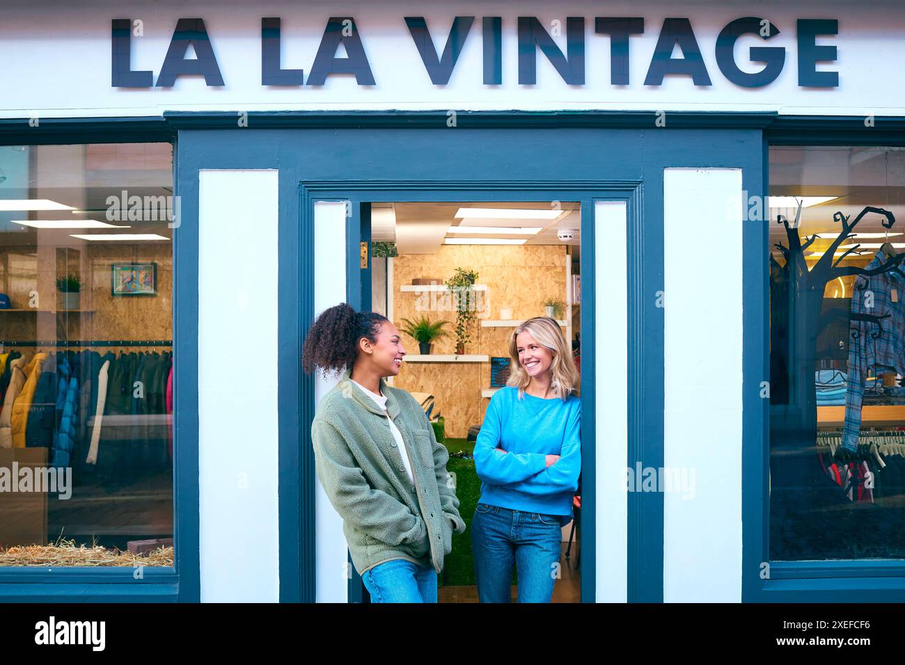 Porträt Von Weiblichen Vertriebsassistenten Oder Eigentümern, Die Außerhalb Von Mode- Oder Kleiderläden Stehen Stockfoto