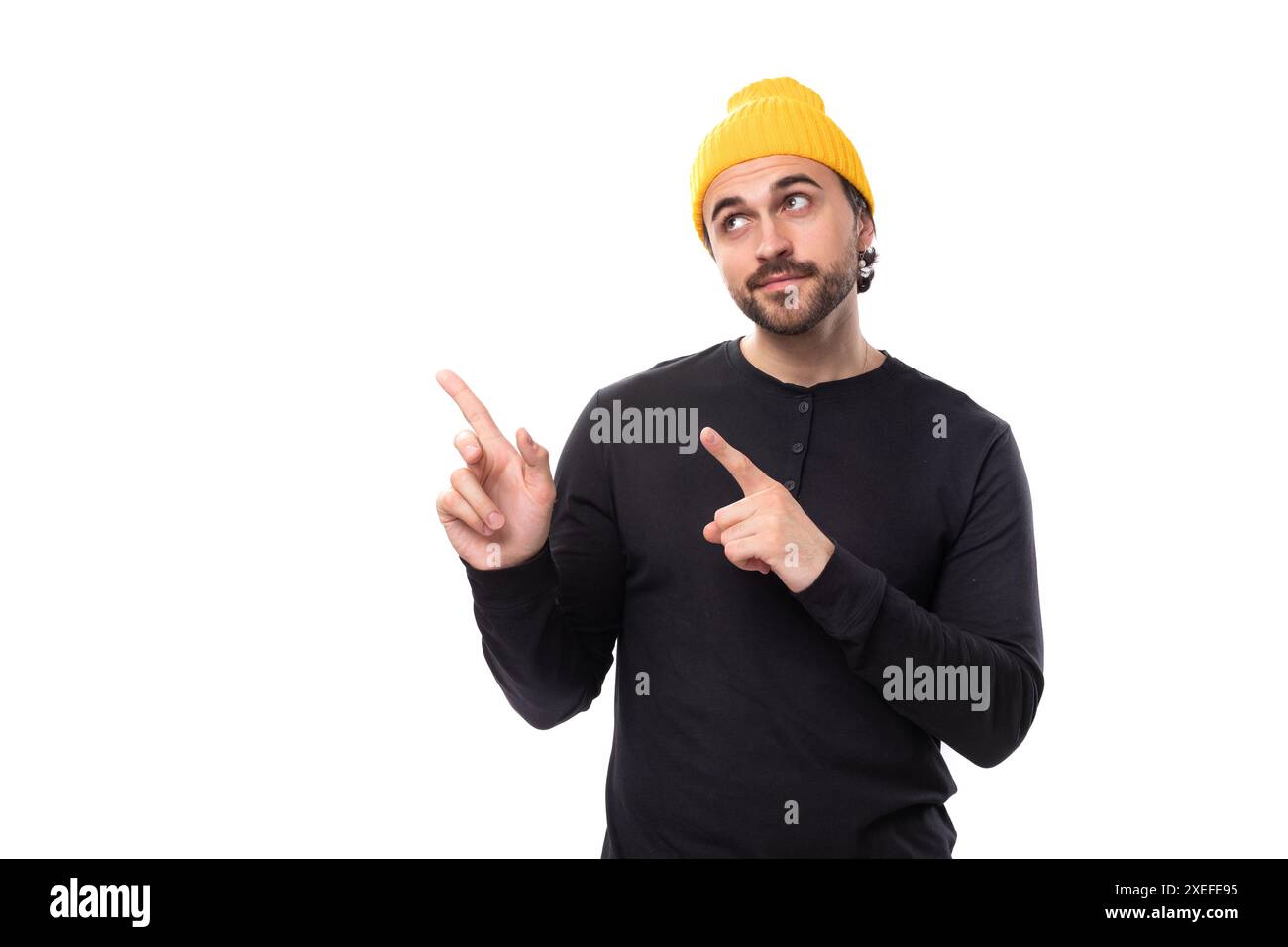 Brutale 30er Jahre authentische brünette männliche Erwachsene in schwarzem Sweatshirt zeigt Finger auf neue Strategie auf weißem Hintergrund mit Kopierraum Stockfoto