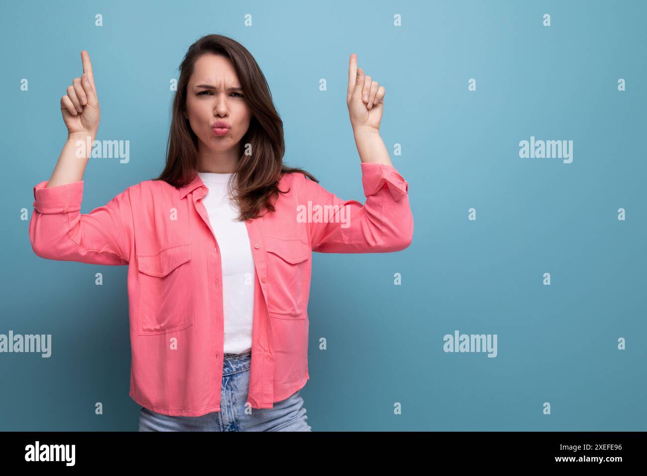 Aktive emotionale schwarzhaarige Dame im lässigen Stil auf Studiohintergrund Stockfoto