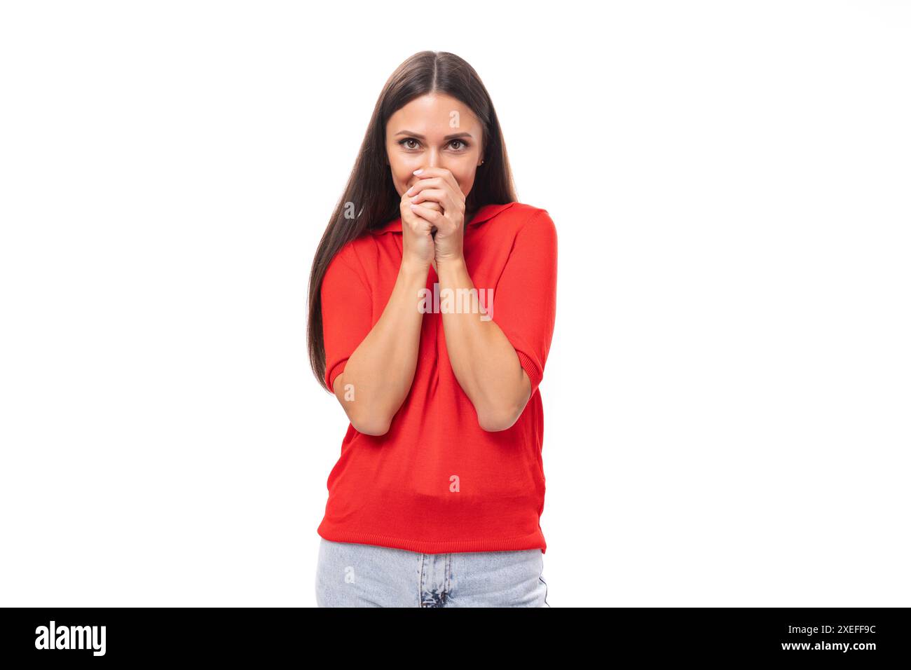 Eine 30-jährige emotionale Kaukasierin mit glatten dunklen Haaren, gekleidet in einem roten Hemd mit kurzen Ärmeln, geht durch Stockfoto