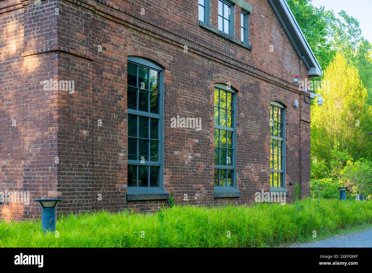 Altes Backsteingebäude mit grünen Fensterrahmen. Stockfoto