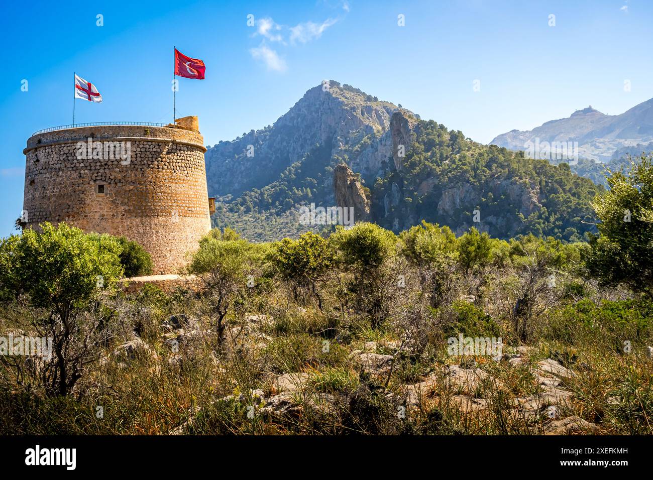 Der Wachturm von Torre Picada, der in der Morgensonne mit Fahnen geschmückt ist, bietet einen Einblick in die Geschichte der Region. Stockfoto