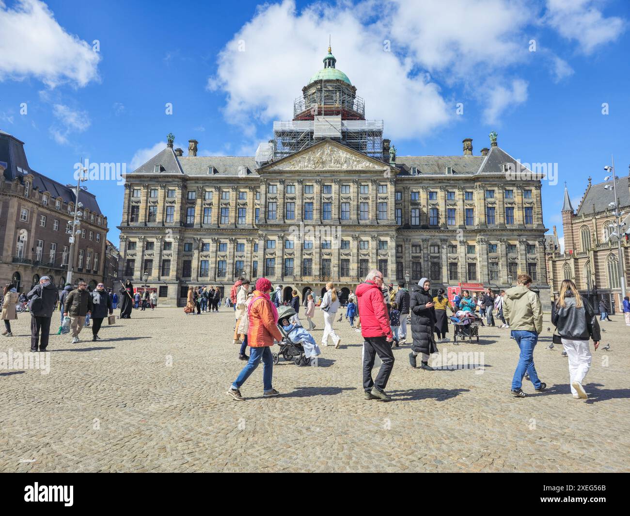 Vor einem imposanten Stadtgebäude spaziert eine vielfältige Gruppe von Menschen zusammen, deren Bewegungen in einem harmonischen und harmonischen Dan synchronisiert sind Stockfoto