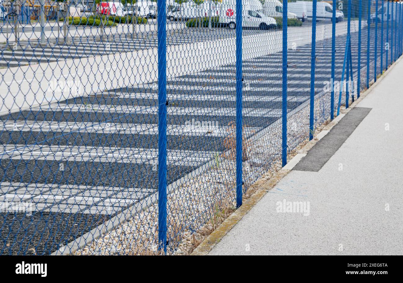 Blauer Maschendrahtzaun aus Stahl um den geschützten Bereich. Schutz von eingeschränkten Bereichen. Stockfoto