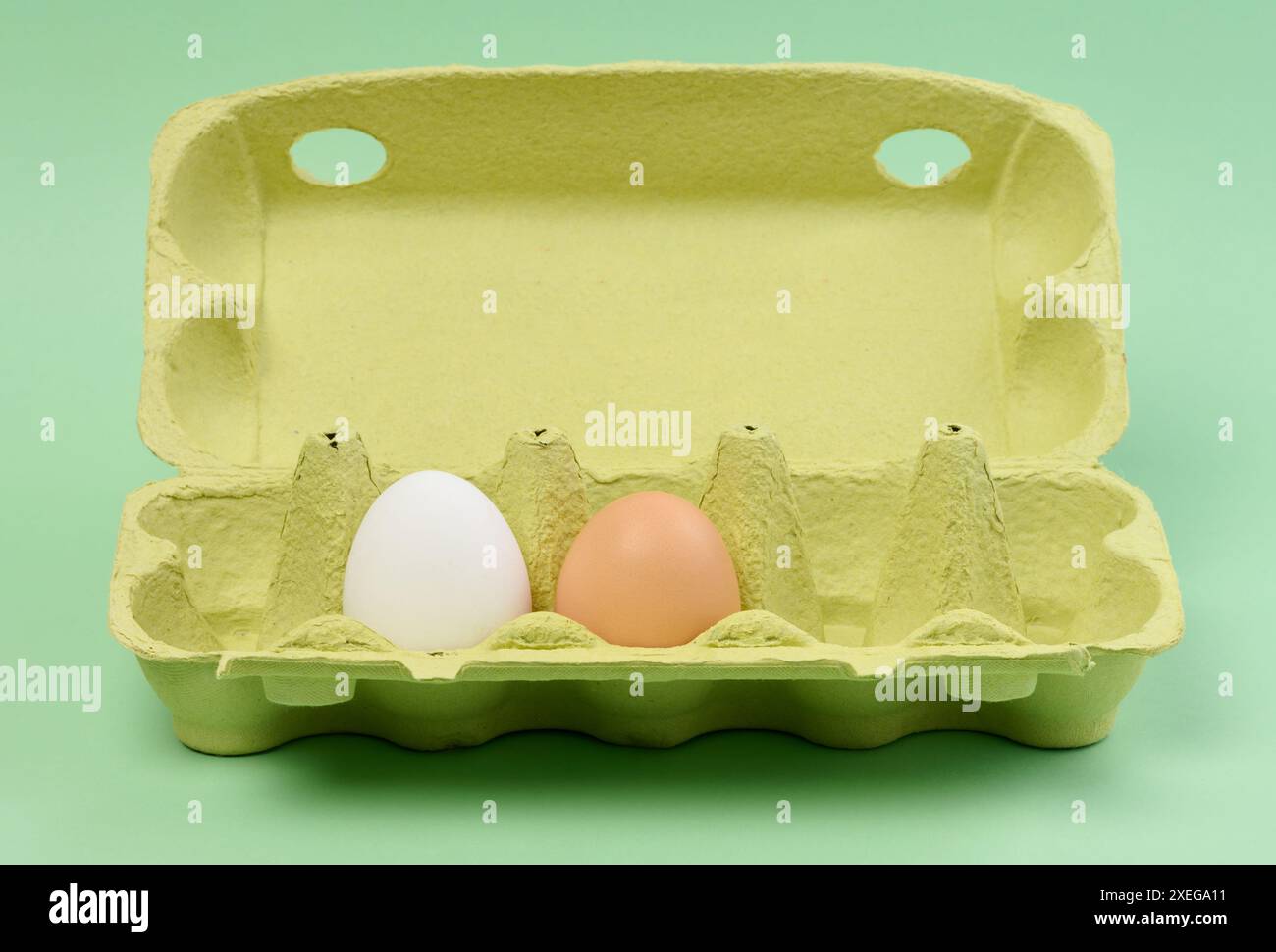 Zwei Hühnereier in einem Papierkarton auf grünem Hintergrund Stockfoto