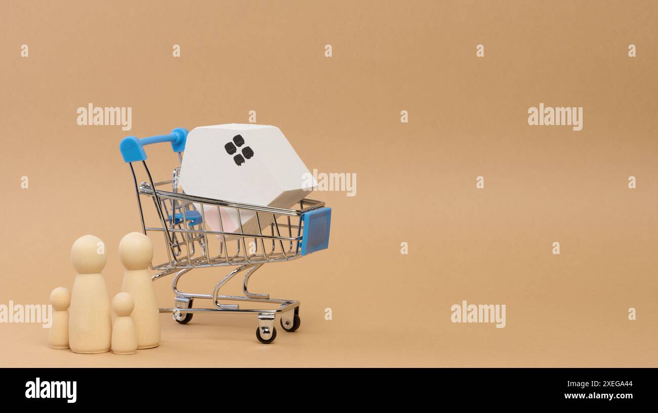 Ein Holzhaus in einem Miniaturwagen und Holzmänner einer Familie mit Kindern. Konzept der Suche nach Mietwohnungen Stockfoto