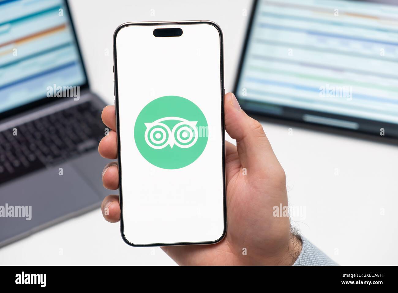 PRAG, TSCHECHISCHE REPUBLIK - 21. JANUAR 2024: TripAdvisor-Logo auf dem Bildschirm des Smartphones in der Hand des Mannes auf dem Hintergrund des Arbeitsplatzes. Stockfoto