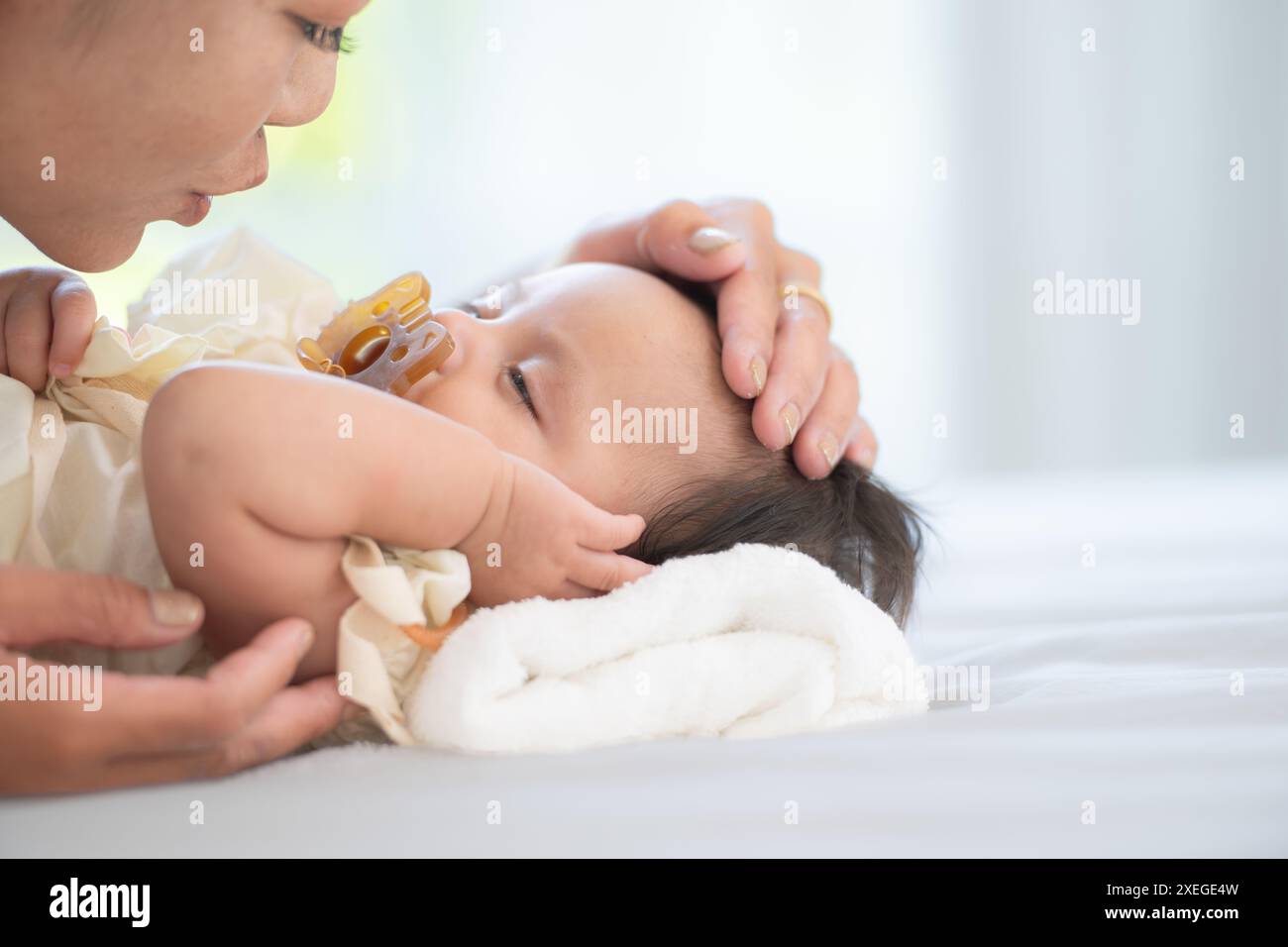 Eine Mutter spielt mit ihrer kleinen Tochter in einem Schlafzimmer voller Wärme und Familie. Stockfoto