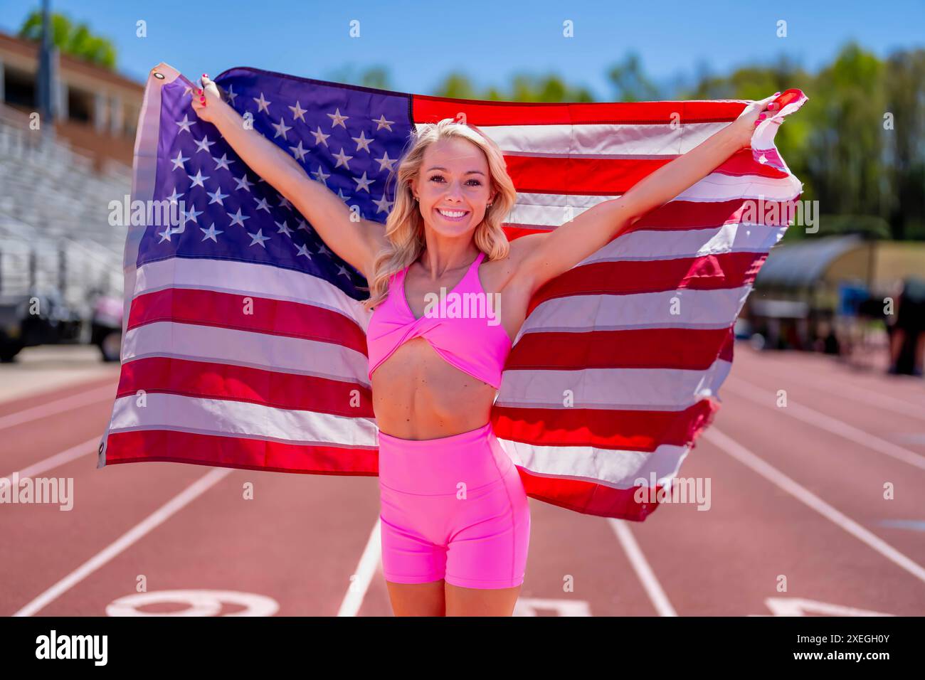 Symbol des Triumphes: Stolzer amerikanischer Athlet ehrt Nation mit Flaggenanzeige Stockfoto