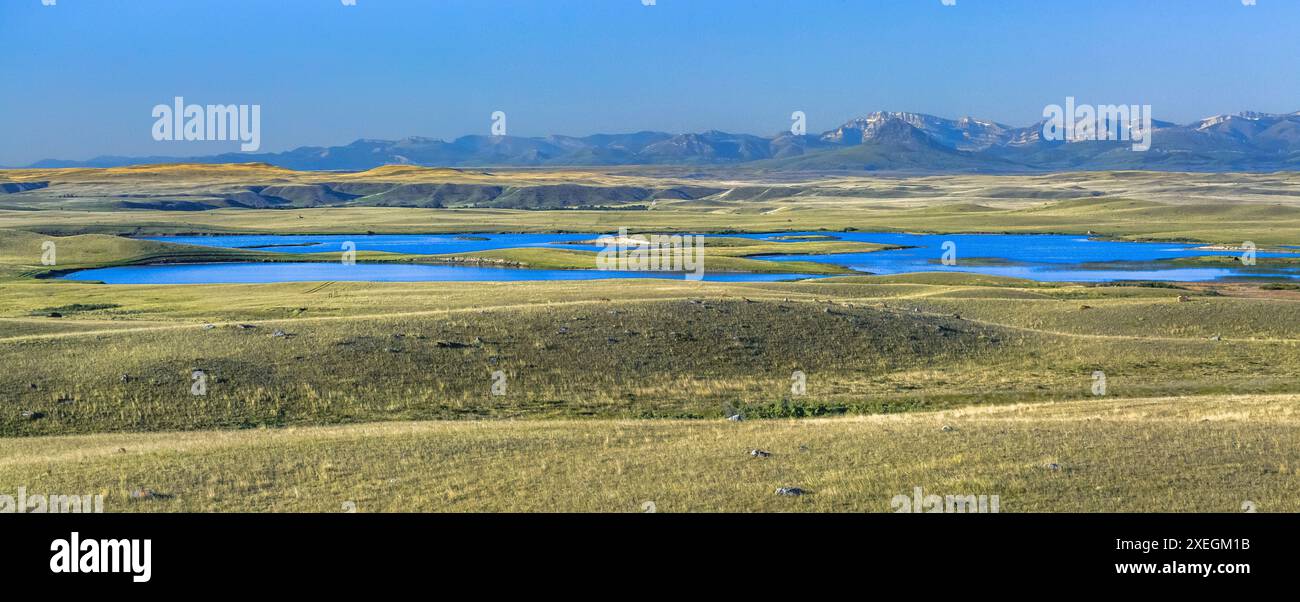 Panorama des geteilten Felsensees in der Prärie unterhalb der felsigen Bergfront in der Nähe von choteau, montana Stockfoto