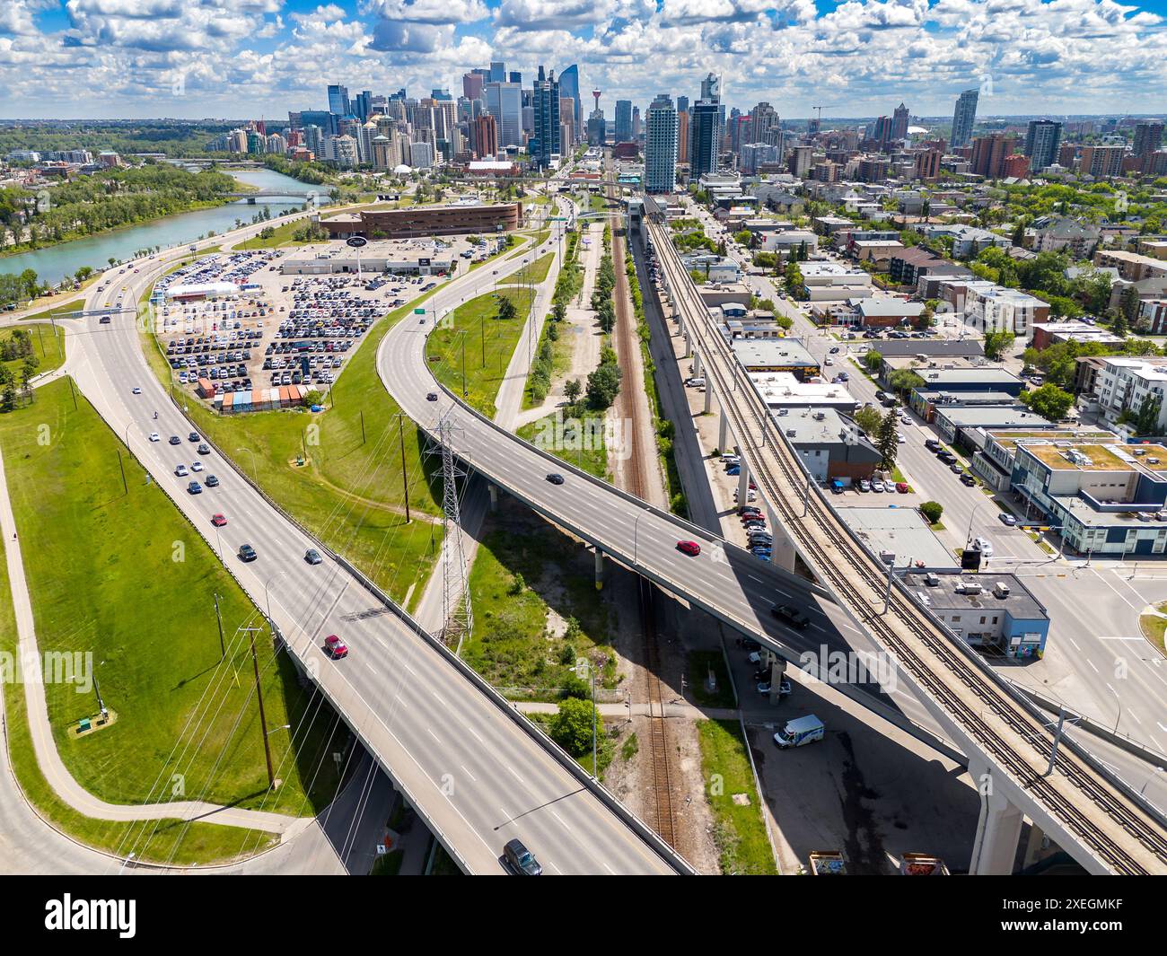 Calgary Skyline aus der Luft mit Blick auf den Pendlerverkehr und erhöhte Linien des öffentlichen Nahverkehrs mit kanadischen Wahrzeichen im Hintergrund in Alberta Kanada. Stockfoto