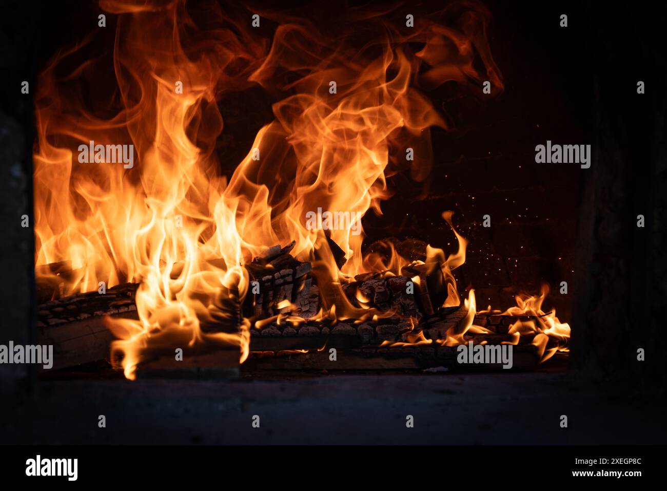 Feuer und verbrenne Kohle im Steinofen. Ofen aus Ziegeln und Ton. Stockfoto