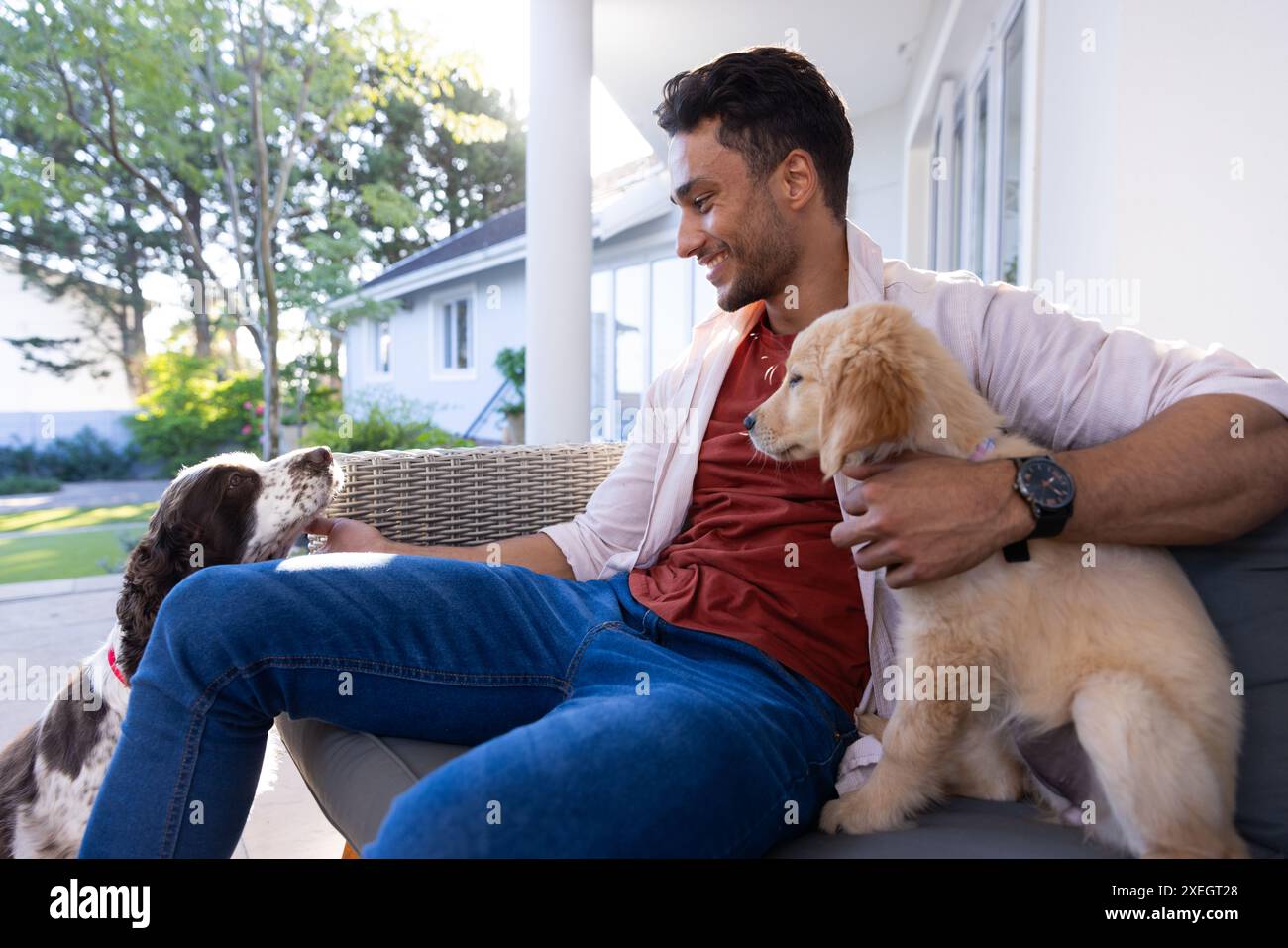 Spielen mit Hunden, Mann genießt Zeit mit Haustieren auf der Außenterrasse Stockfoto