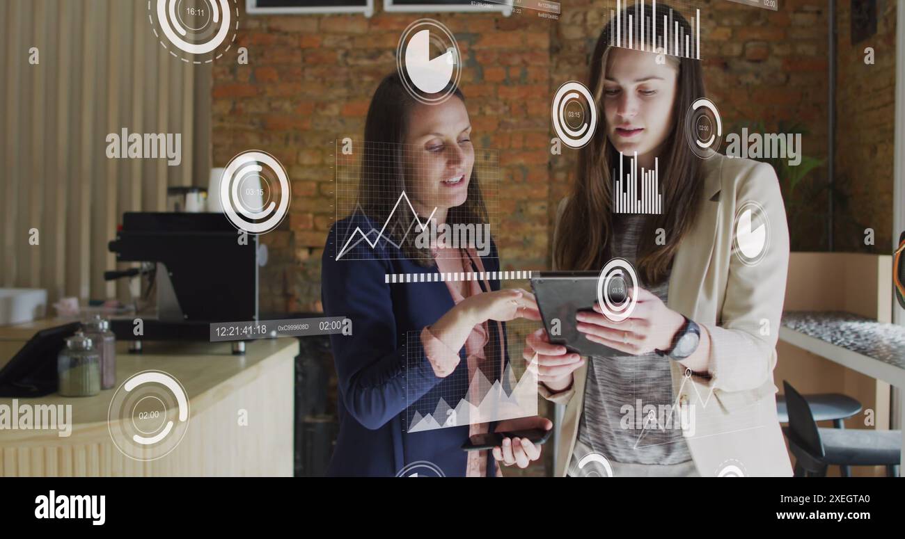 Bild der statistischen Datenverarbeitung über zwei kaukasische Frauen, die über ein digitales Tablet diskutieren Stockfoto