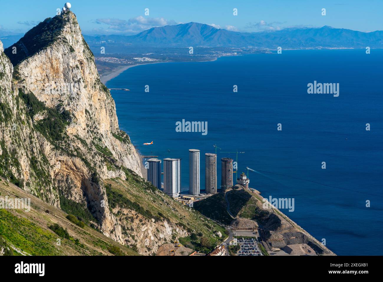 Das Flugzeug landet am Flughafen Gibraltar mit Blick auf den Felsen und neue Wolkenkratzer werden gebaut Stockfoto