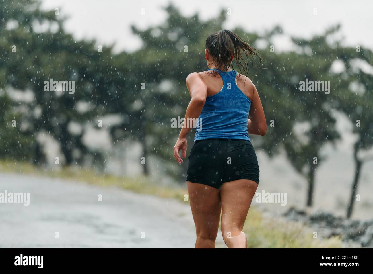 Unaufhaltsam: Ein entschlossener Athlet trainiert durch den Regen, um Marathon Glory zu verfolgen Stockfoto