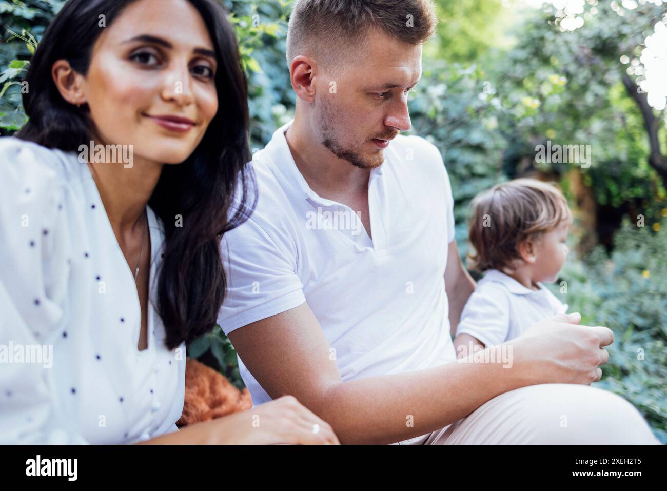 Junge Paare und ihr Sohn draußen an sonnigen Sommertagen. Stockfoto