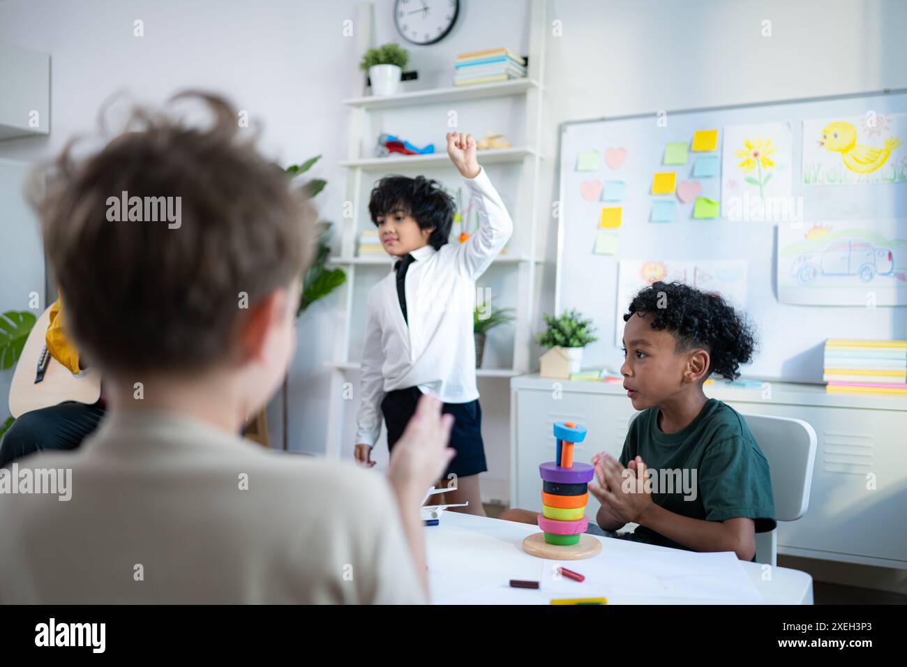 Im Unterricht singen Lehrer und Schüler zusammen, und die Jungs tanzen glücklich. Stockfoto