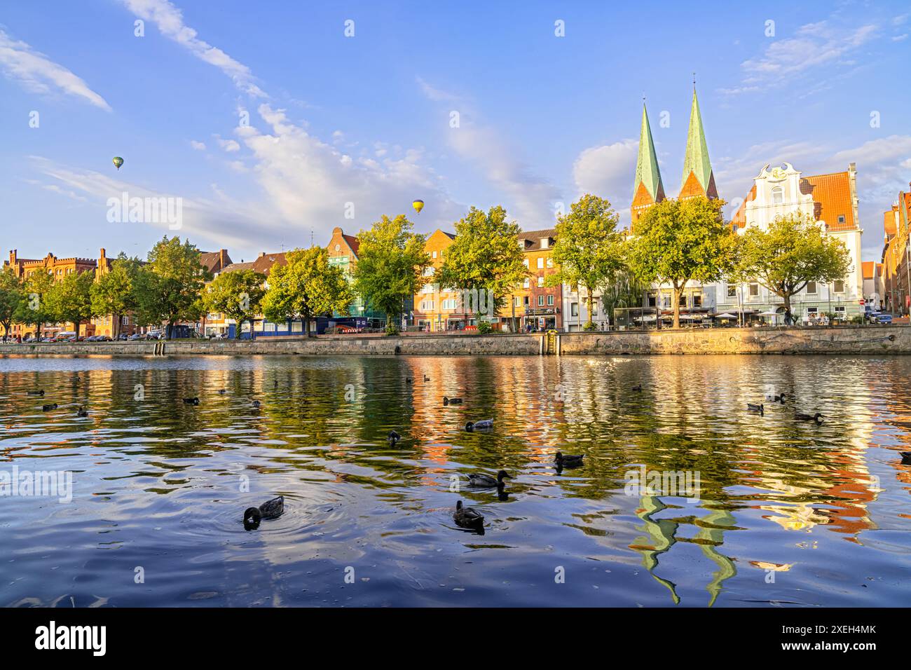 Die Altstadt von Lübeck, Deutschland mit Enten im Fluss und Ballons am Himmel Stockfoto