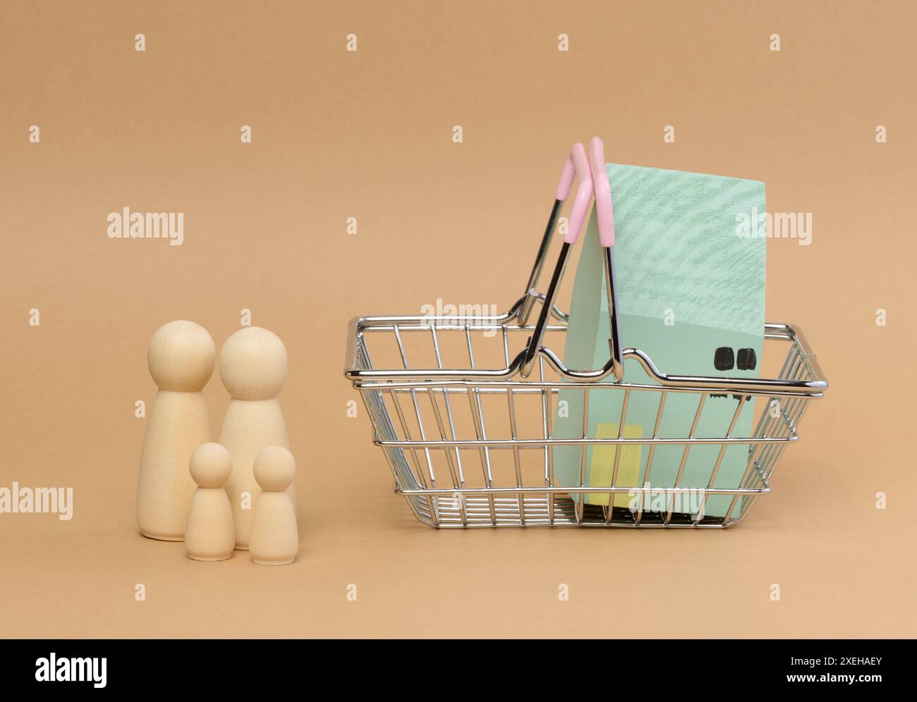 Ein Holzhaus in einem Miniaturwagen und Holzmänner einer Familie mit Kindern. Stockfoto