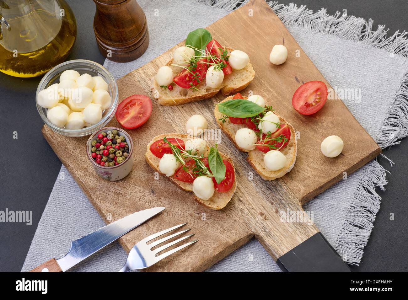Runder Mozzarella, Kirschtomaten und Mikrogrün auf einem Stück Weißbrot, ein gesundes Sandwich Stockfoto