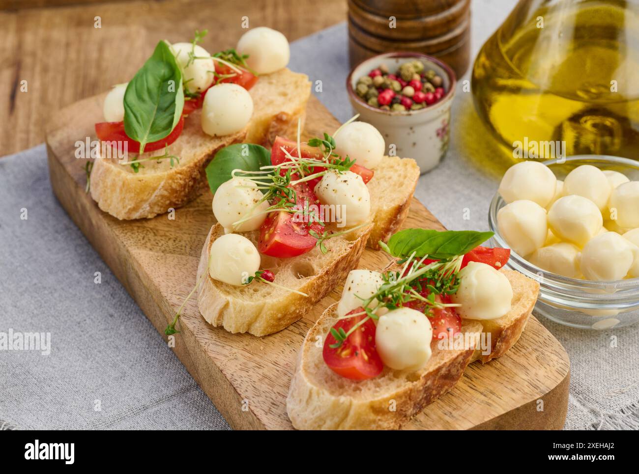 Runder Mozzarella, Kirschtomaten und Mikrogrün auf einem Stück Weißbrot, ein gesundes Sandwich Stockfoto