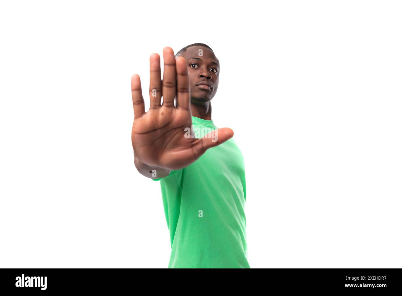 Porträt eines jungen, klugen afrikanischen Mannes in grünem T-Shirt und Jeans isoliert auf weißem Hintergrund Stockfoto