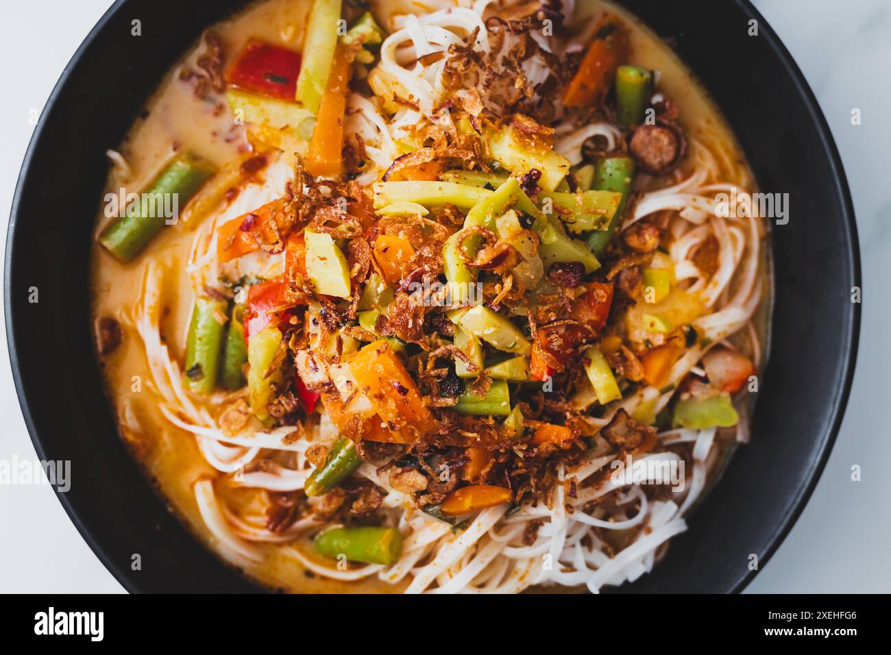 Pflanzliche Dan Dan Dan Reisnudeln Suppe mit gemischtem Gemüse und scharfer Sauce, gesunde vegane Lebensmittelrezepte Stockfoto