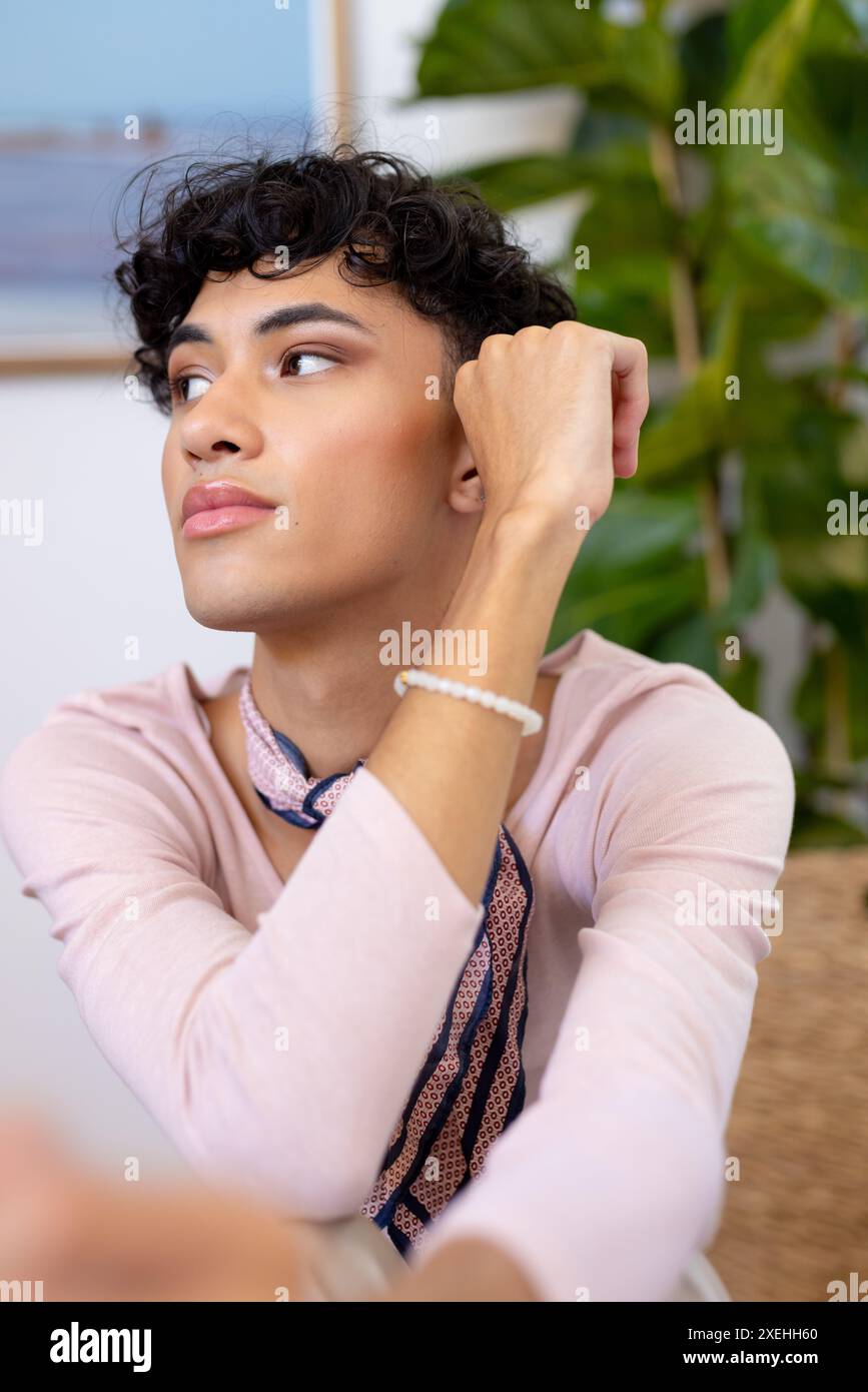 Überlegt, Transgender-Transgender-Frau, die zu Hause mit Hand am Kinn sitzt Stockfoto