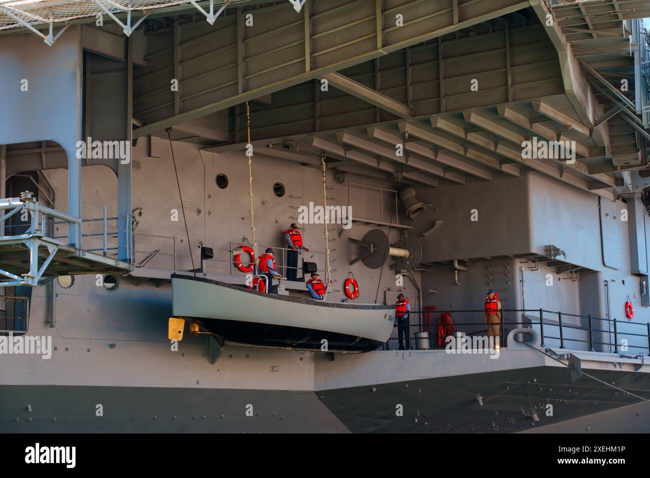 San Diego, Kalifornien - 16. April 2024: Nahaufnahme des Flugzeugträgerdecks der USS Midway mit Rettungsbooten und Besatzungsmitgliedern. Stockfoto