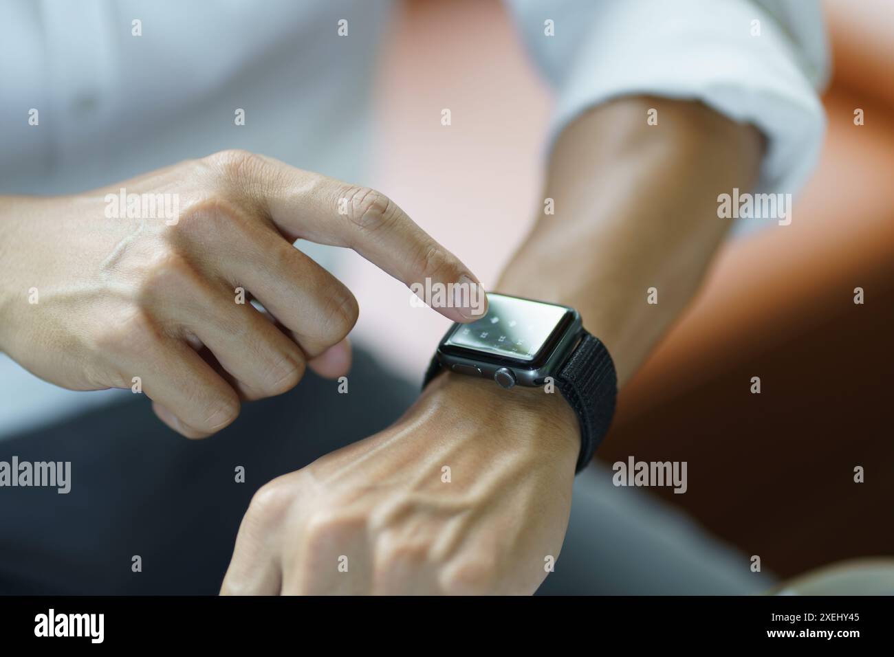 Geschäftsmann, der atÂ Smart Watch in Office Online CONNECT Gadget-Technologie sucht Stockfoto