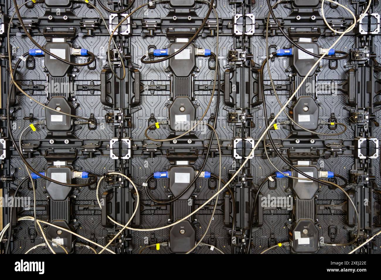 Textur der hinteren Ansichtsfelder. Stromeingangs- und Ausgangsleitung sowie Dateneingangs- und -Ausgangsstecker. Digitaler elektronischer Bildschirm. Rückseite des großen LED-Bildschirms Stockfoto