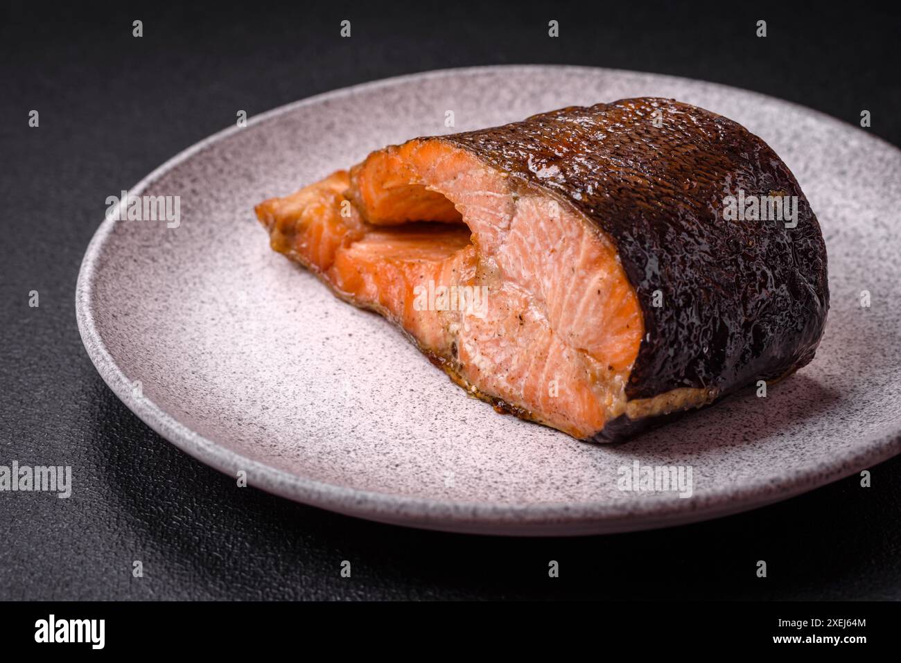 Frisch gekochtes, köstliches Lachssteak mit Gewürzen und Kräutern, gebacken auf einem Grill Stockfoto