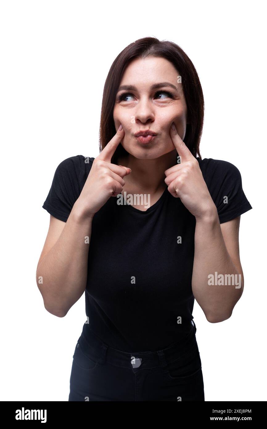 Junge lächelnde Europäerin in einem einfachen T-Shirt-Grimaces Stockfoto