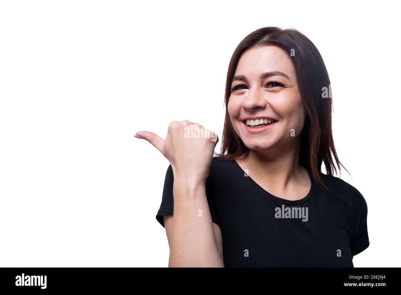 Junge freundliche Frau mit schwarzem Haar, die ein schwarzes T-Shirt auf weißem Hintergrund mit Kopierraum trägt Stockfoto